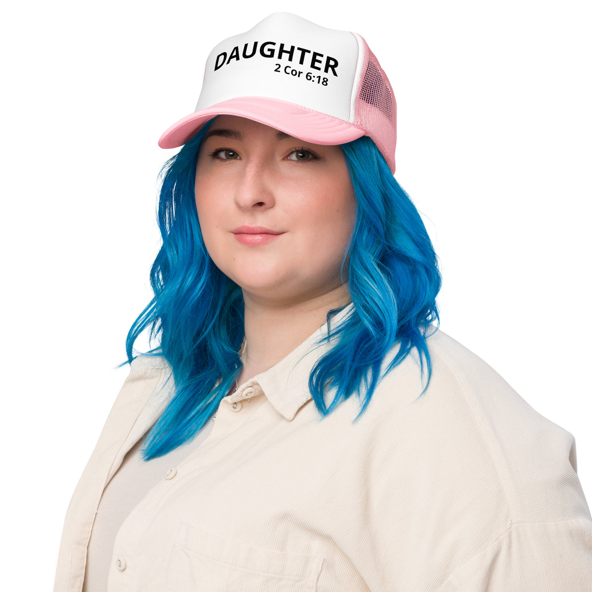 A person with bright blue hair wearing a pink and white trucker Christian hat that says 'DAUGHTER 2 Cor 6:18' in black text, paired with a cream-colored collared shirt, against a solid white background.