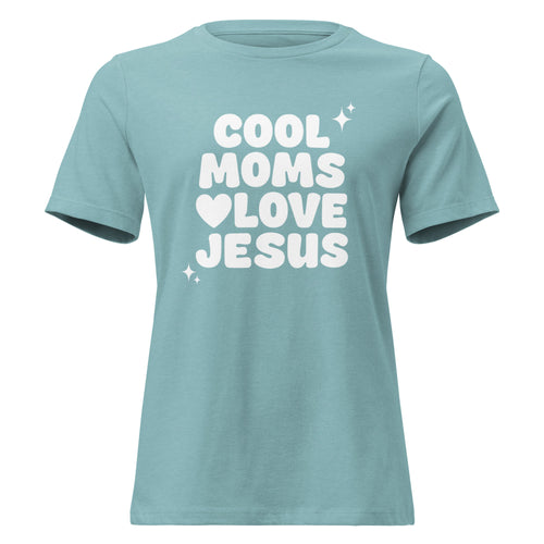 A short-sleeve crewneck Christian t-shirt in a dusty teal color, featuring the text 'COOL MOMS LOVE JESUS' printed in bold white letters on the front, accompanied by small white star and heart graphics.